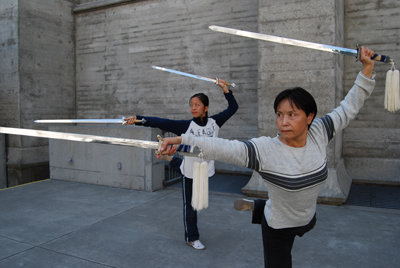 Master artist Ling Mei Zhang (right) and apprentice Ruth Yafonne Chen practicing Chinese sword dance.