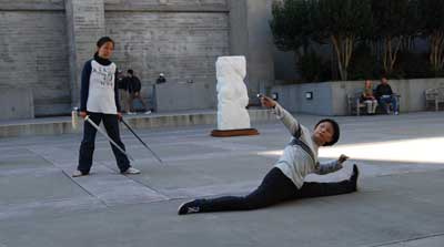 Apprentice Ruth Yafonne Chen watches as master artist Ling Mei Zhang (right) demonstrates Chinese sword dance.