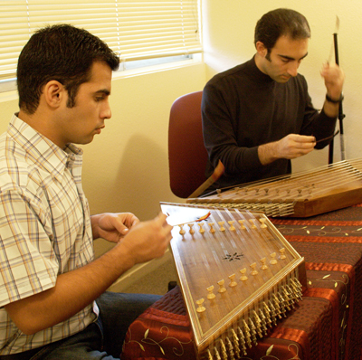 Master artist Bahram Osqueezadeh (right) and apprentice Aero Saffarzadeh during one of their lessons in Persian santur music.  The thin and delicate wooden mallets used to play the santur, called mezrab, are held between the index and middle fingers and require finesse to strike the santur’s 72 strings.