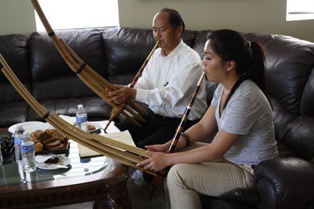 Gorlia Xiong and her father Wang L. Xiong practicing the qeej at home