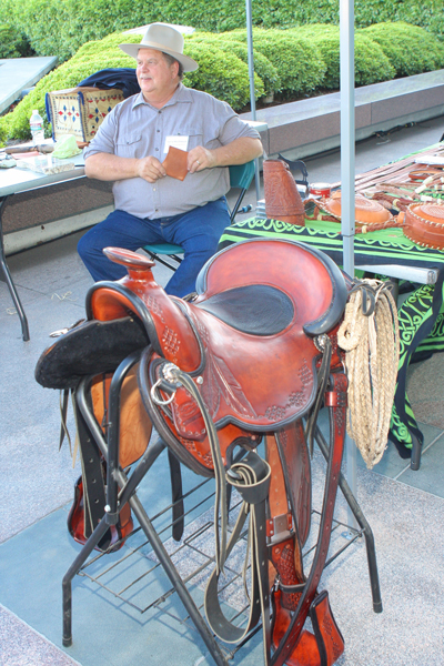 Master saddle maker Garry McClintock forefronted by one of his saddles