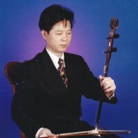 Caption: Master Ben conducts the Cantonese opera ensemble while performing on the erhu (a traditional two-string Chinese bowed instrument), guiding the musicians throughout the performance.

Credit: Photo courtesy of Jing Ying Cantonese Opera Institute.