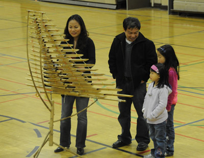 A family looks on as master musician Vanessa Vo Van Tranh demonstrates the bamboo xylophone known as the dan t’rung.