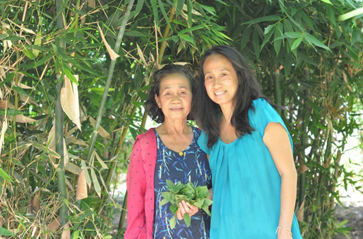 Leanne Mounvongkham (left) and her daughter-apprentice Khampha Thephavong in front of Leanne’s backyard bamboo garden.