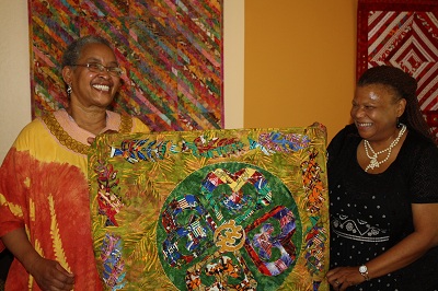 Helen Anderson (apprentice, left) and Patricia Montgomery (master, right) holding Anderson’s quilt, The Answer Prayer.