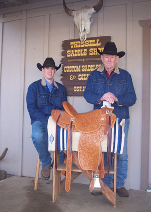 Photo of master saddlemaker Gaylerd Thissell and his apprentice and grandson Lance Zazuetain front of Thissell Saddle Shop